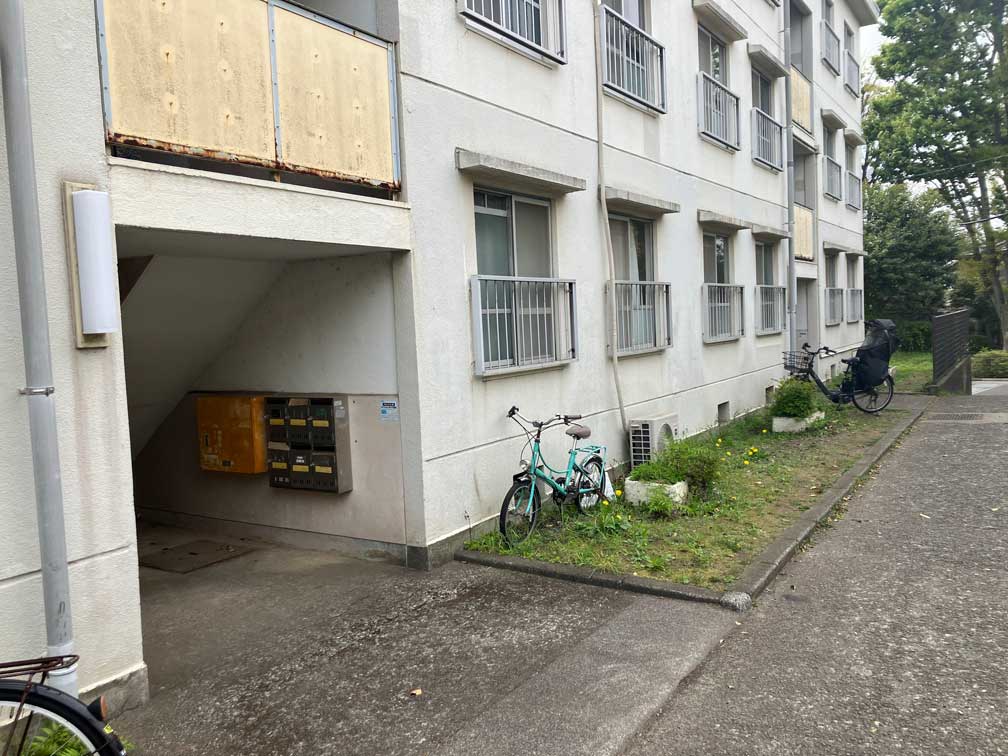 吉祥寺北町にあるJR東日本社宅の建物外観。窓の一部が板で覆われ、建物脇に自転車が置かれている。