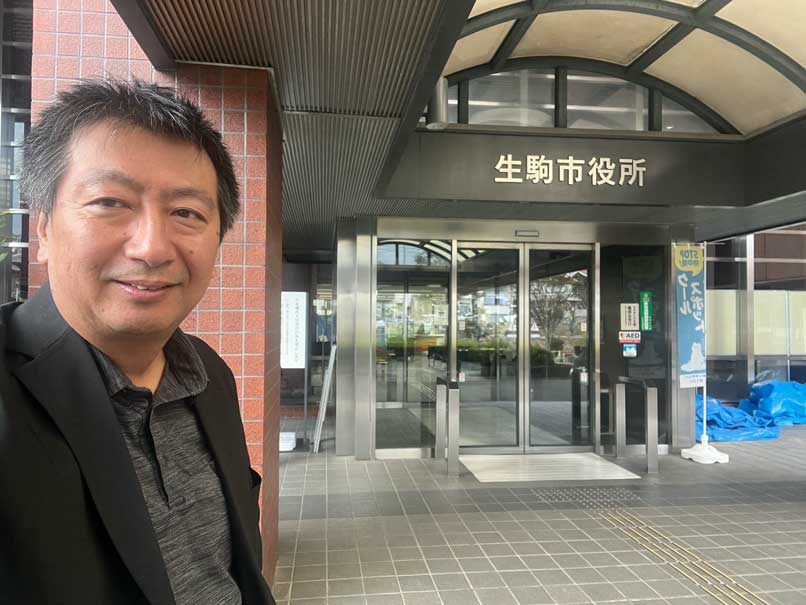 生駒市役所の入口前に立つ武蔵野市議会議員の藪原太郎